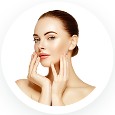 A person with smooth, glowing skin gently touches their face with both hands. They have slicked-back hair and a subtle smile. The background is plain white, and the image is circular.